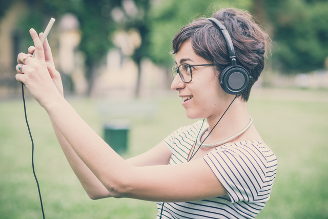 young hipster woman listening to music selfie